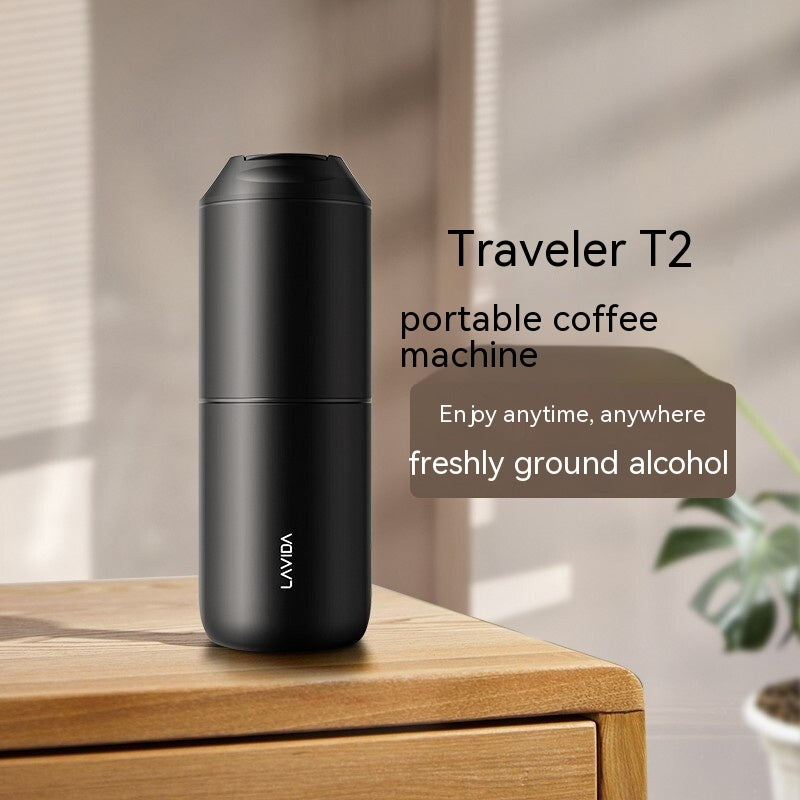 Black portable coffee machine on a wooden surface with a blurred background