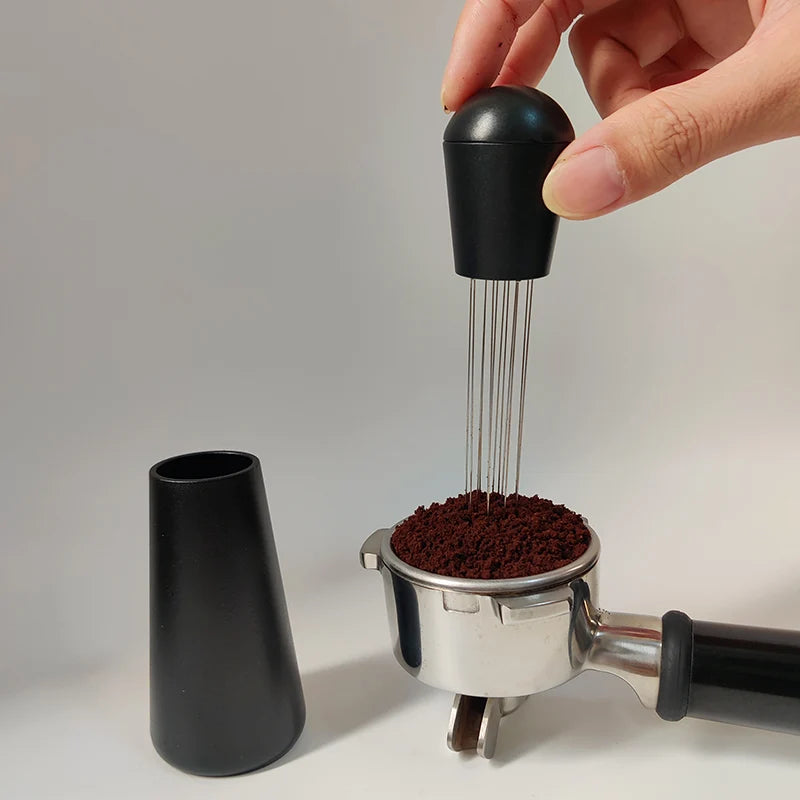 Hand using a manual coffee grinder with coffee beans on a neutral background