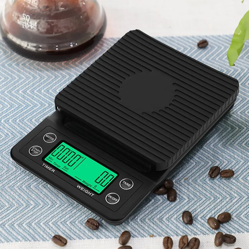 Digital kitchen scale with a green display on a table with coffee beans and a glass of coffee.