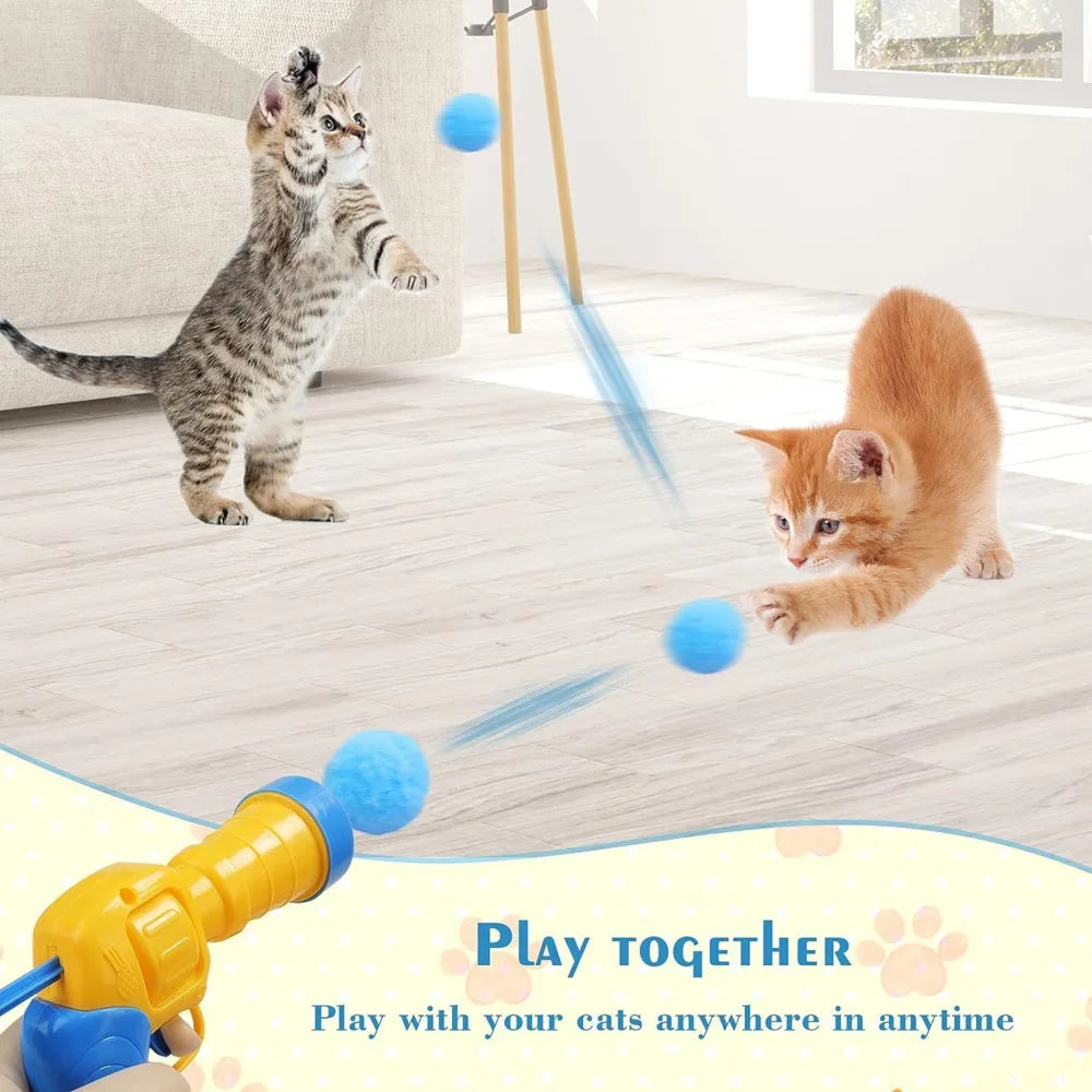 Two kittens playing with a toy gun on a wooden floor.