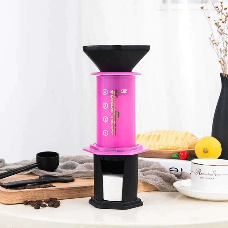 Pink and black coffee brewing device on a kitchen counter with a white background