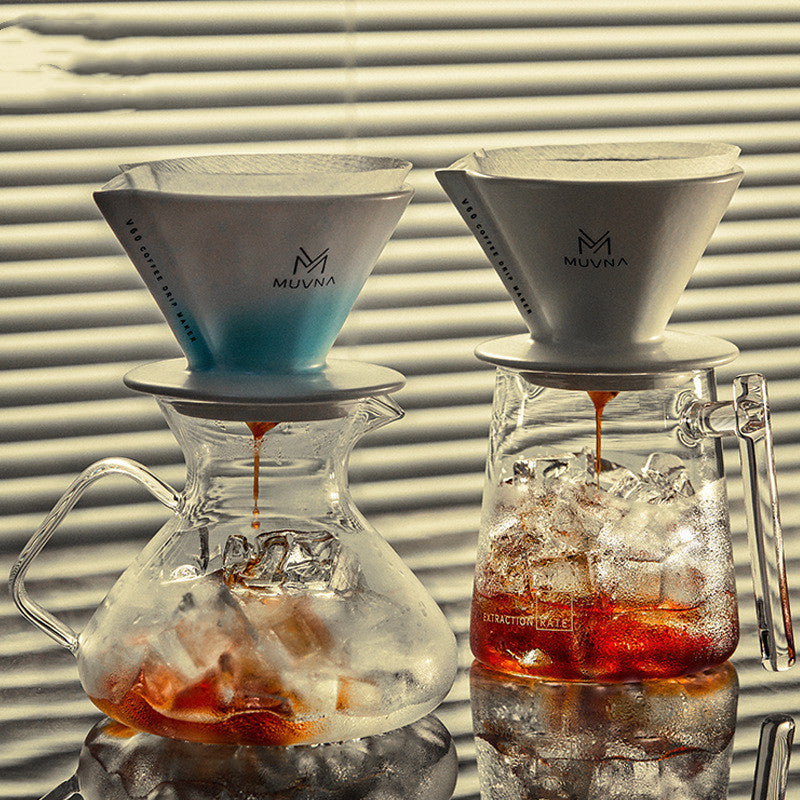 Two MUVNA coffee brewing devices with glass carafes on a reflective surface.