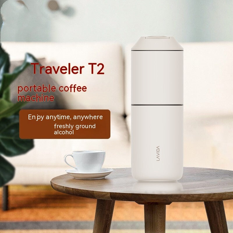 Portable coffee machine labeled 'Traveler T2' on a table with a cup of coffee.