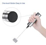 Hand holding a metal tool with a close-up of its button on a white background
