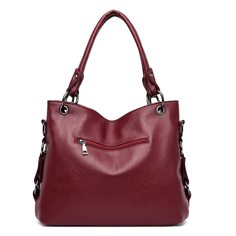 Maroon handbag with a visible zipper on a white background