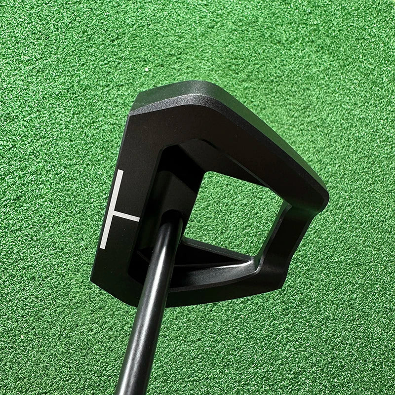 beginner golf putter UK - A close-up of a black golf putter head with a white letter 'T' logo, resting on a green artificial turf background.
