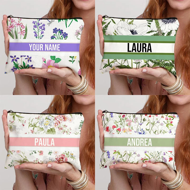 Four floral pouches with different names printed on them, held by a person.