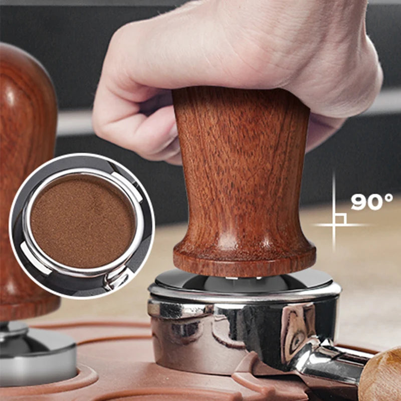 Wooden coffee tamper being used on a coffee grinder with close-up of ground coffee.