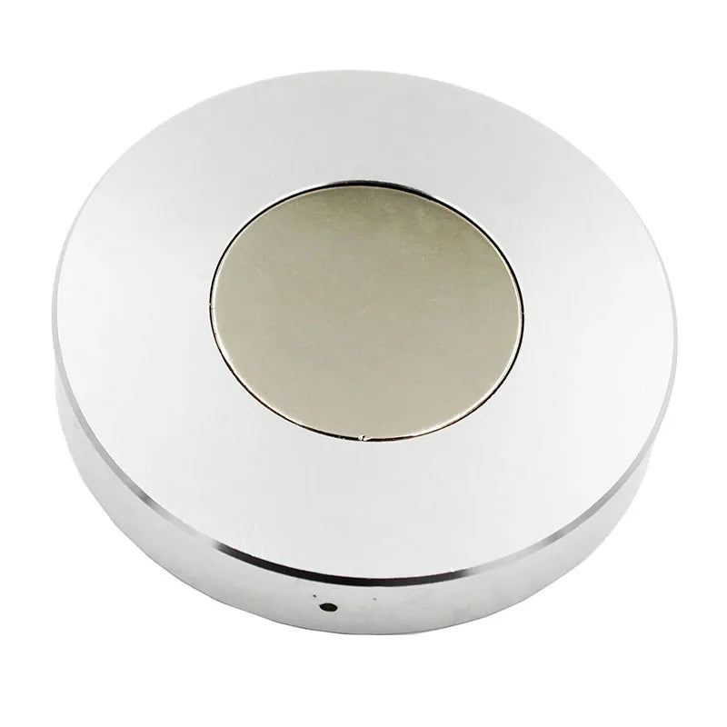 Round metallic object with a central circular component on a white background