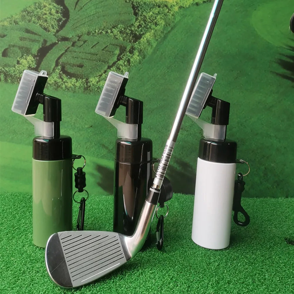 Golf club with three cleaning bottles on a green surface
