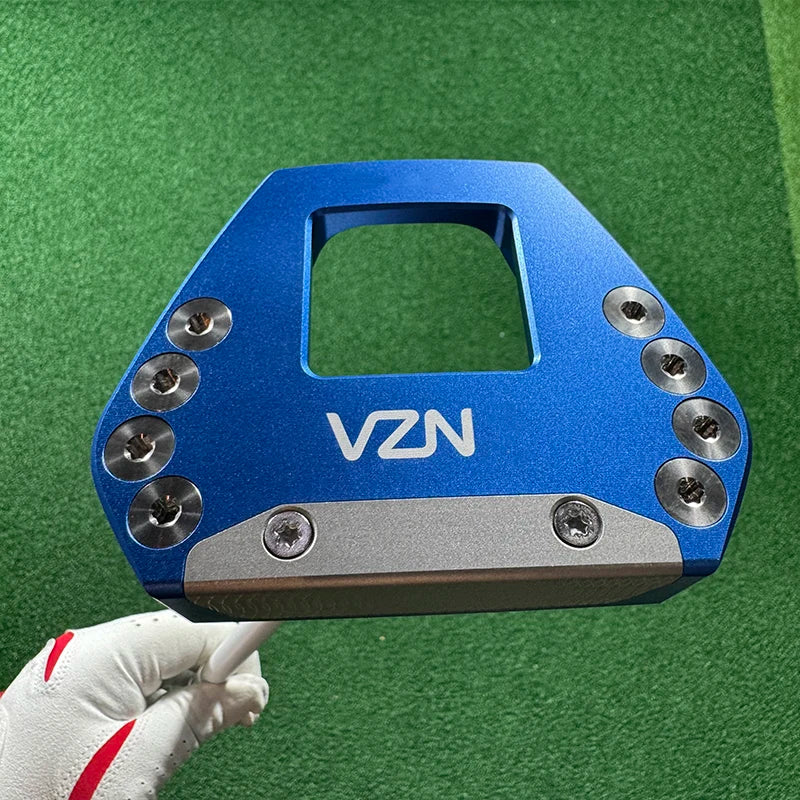 beginner golf putter UK - A blue VZN golf club head insert or clubface cap with silver screws, held by a white golf glove against a green turf background.