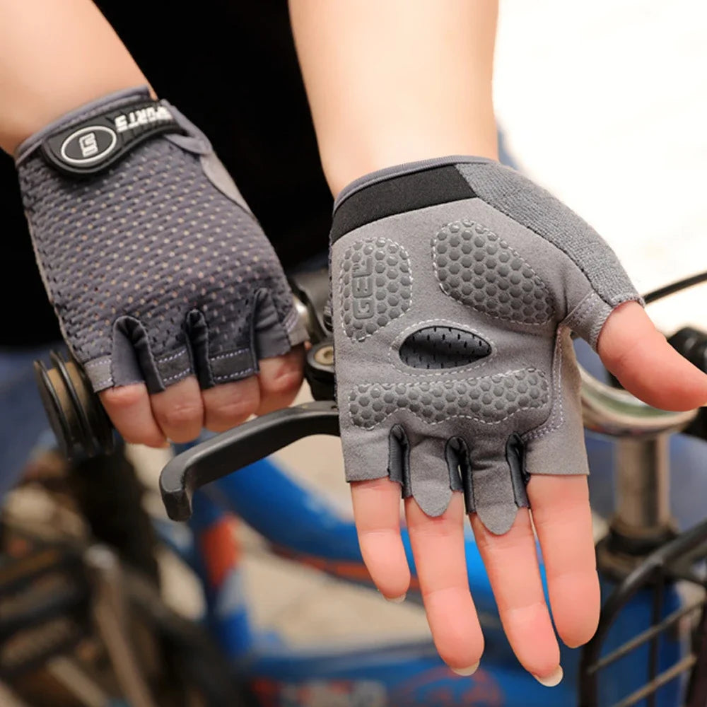 Kids golf gloves UK  - Gray cycling gloves with fingerless design held by a person on a blurred background