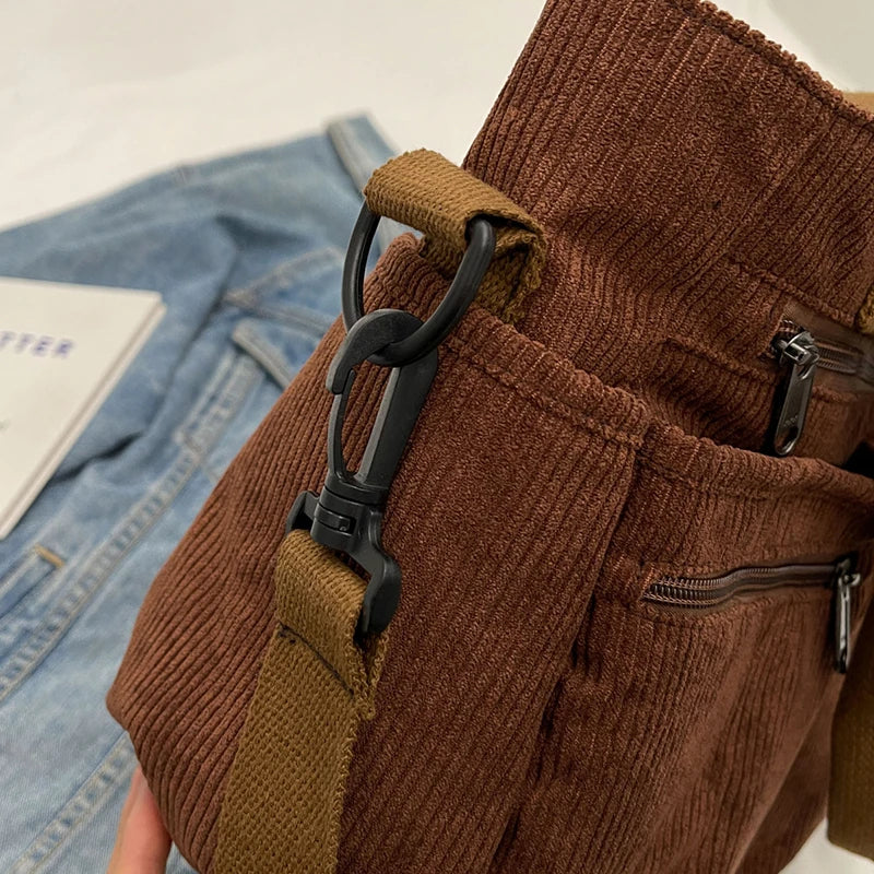 Brown corduroy pants with a belt and black buckle on a white background