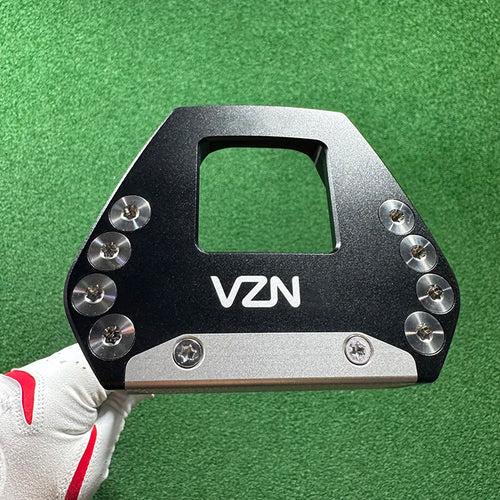 beginner golf putter UK - A VZN golf club head insert or clubface protector shown being held by a hand wearing a white and red golf glove, against a green turf background.