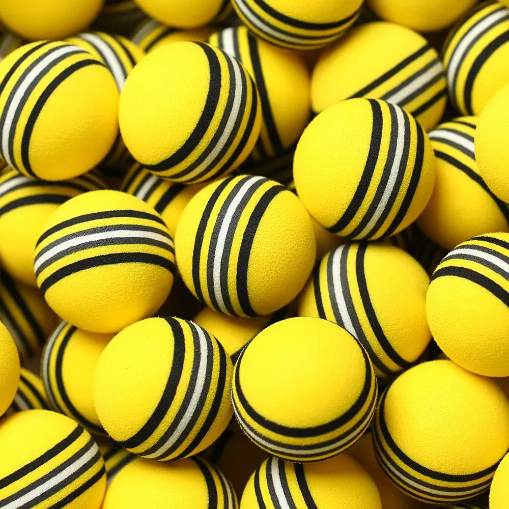Yellow foam golf balls UK  with black and white stripes arranged in a pile