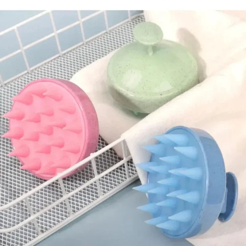 Three silicone scrubbers in pink, green, and blue on a white rack with a light blue tiled background.