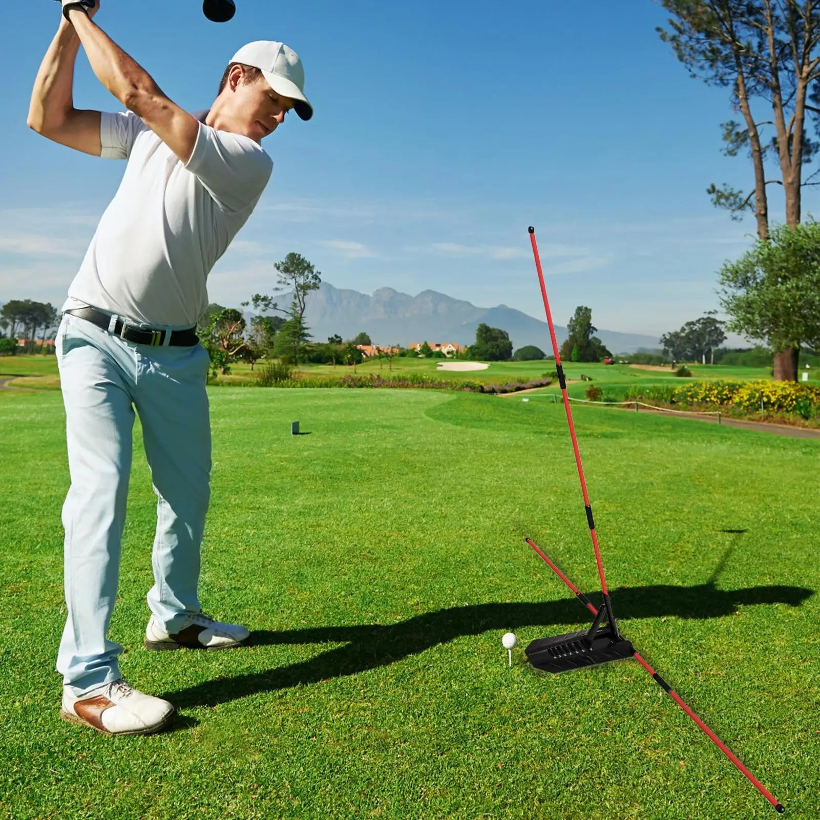 Golf alignment sticks UK - Man playing golf on a green course with mountains in the background