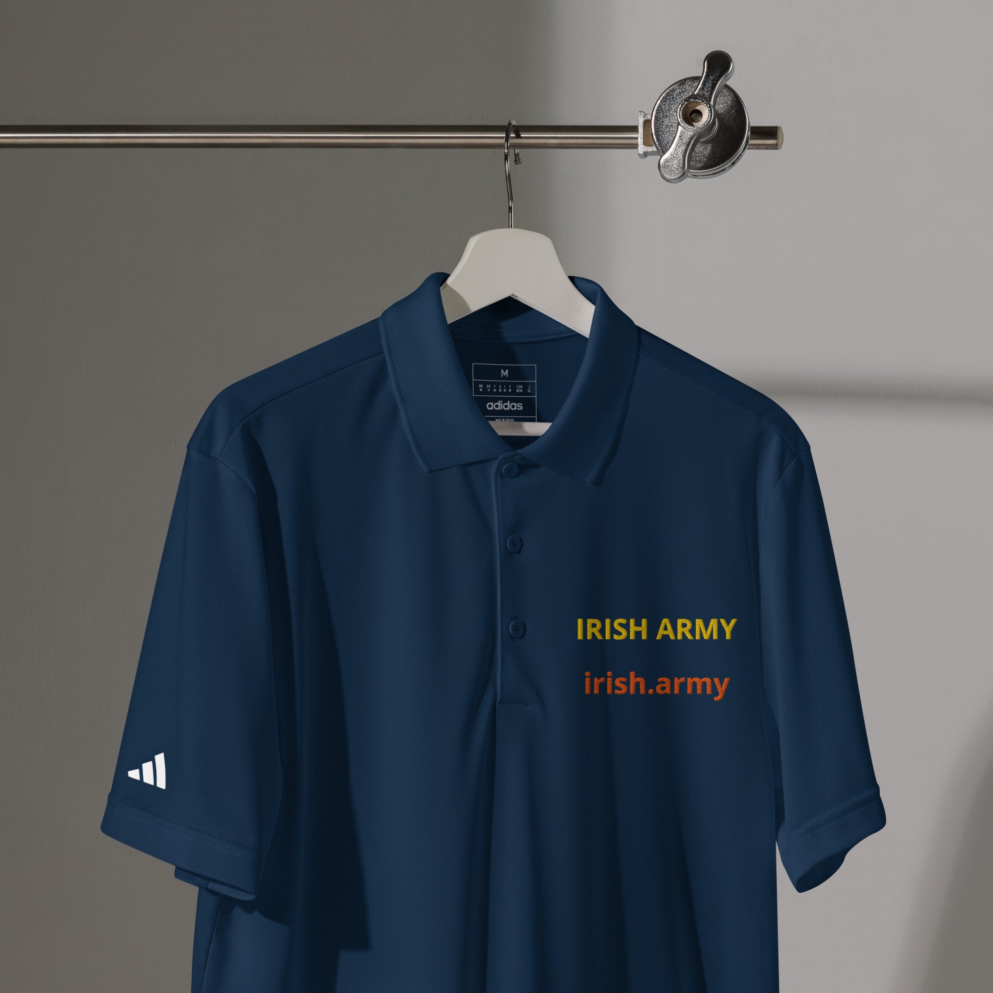 Navy blue polo shirt with 'Irish Army' text on a hanger against a gray background