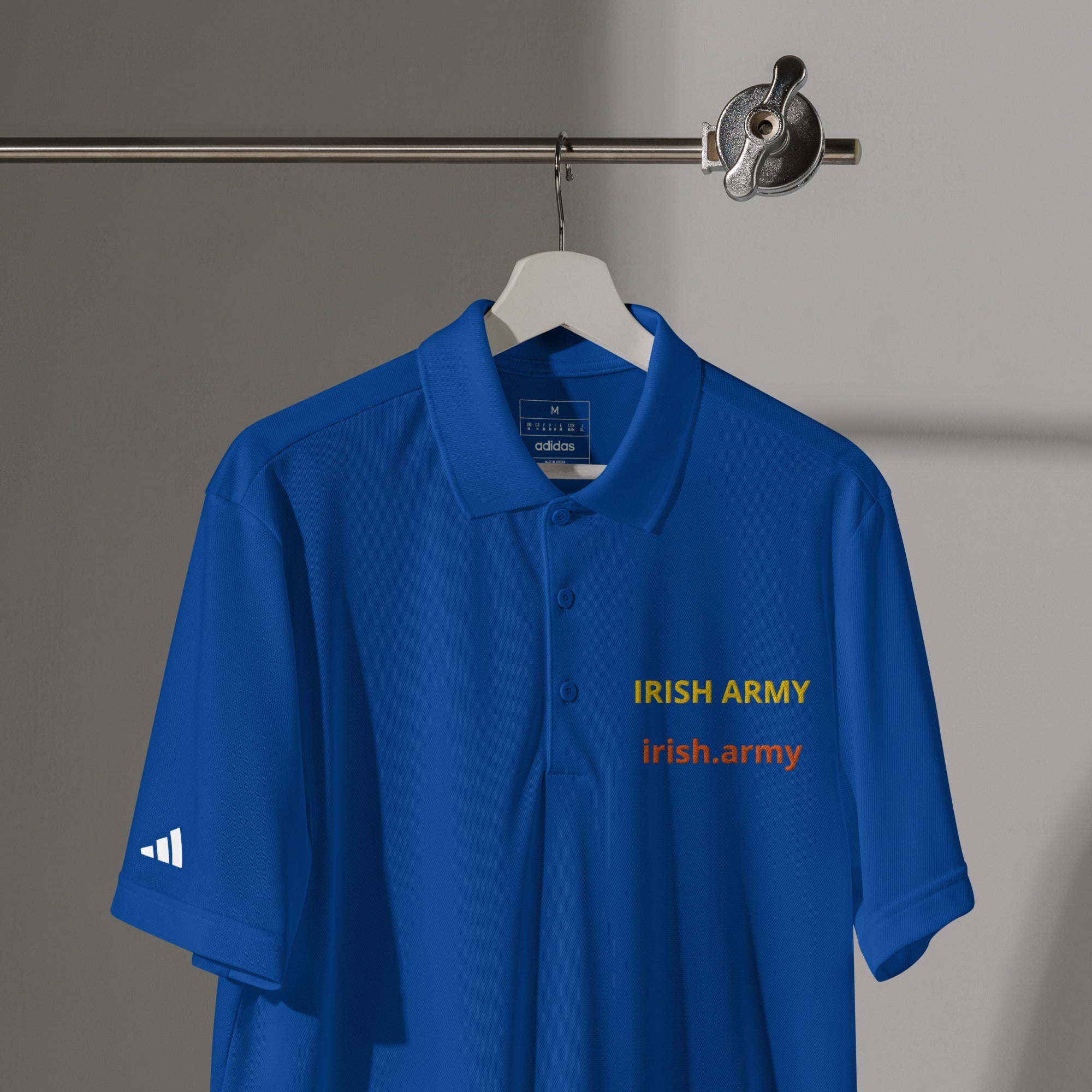 Blue polo shirt with 'Irish Army' text on a hanger against a gray background