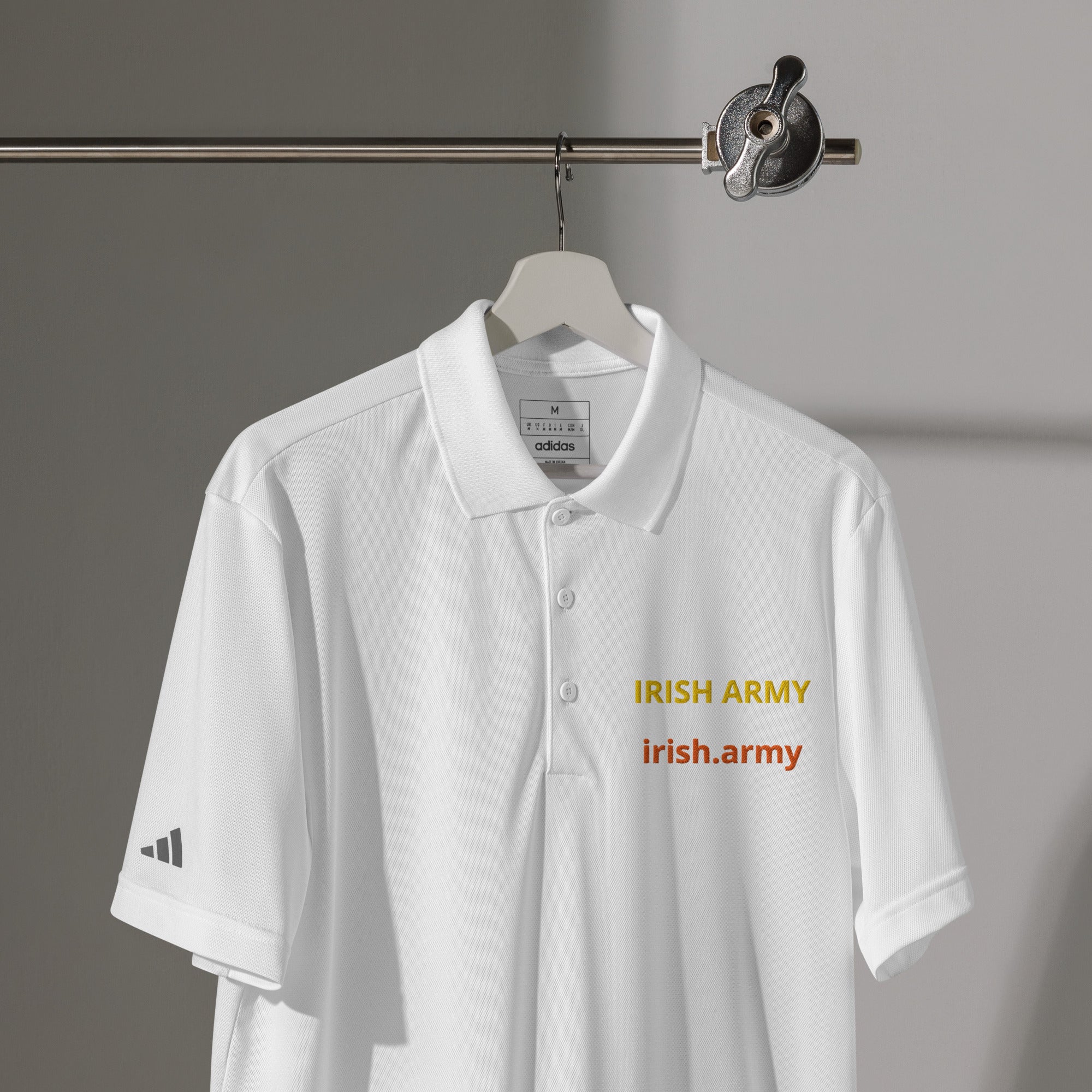 White polo shirt with 'Irish Army' text on a hanger against a gray background