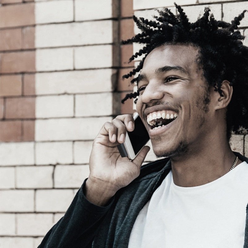 Happy man using OISLE Universal Type-C Battery External Power Bank with a smartphone, showcasing portability and ease of use.